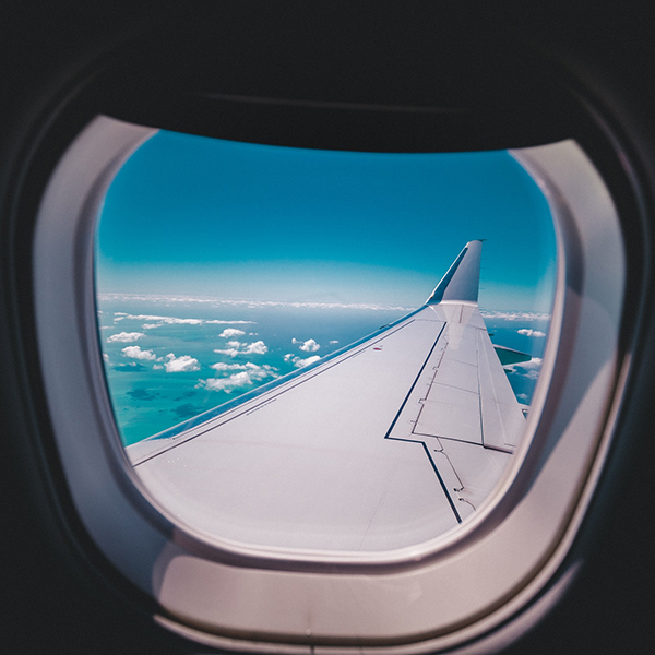 An airplane wing seen through an airplane window | Coor